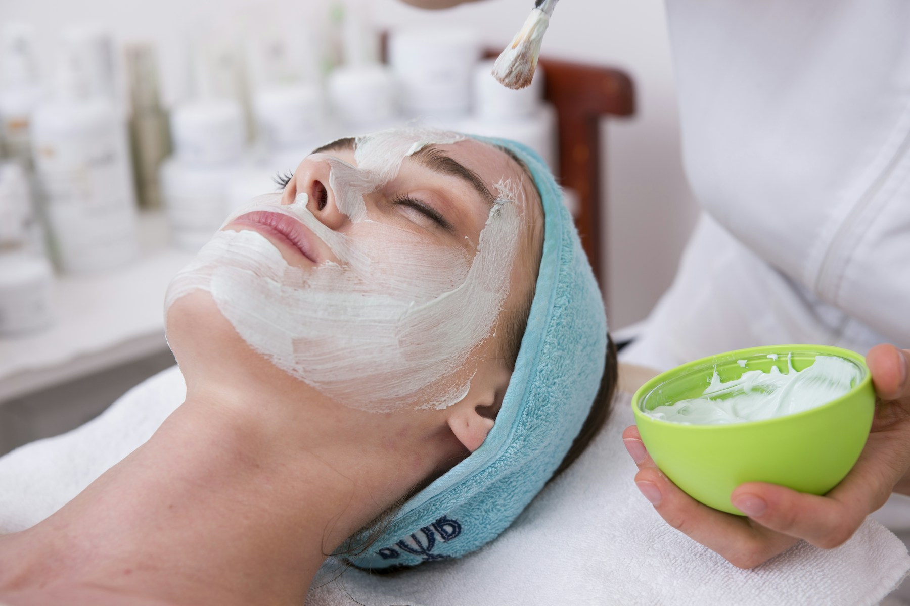 Woman receiving a white facial mask treatment